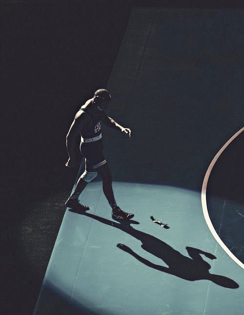Wrestler walking to mat in dim lit lighting